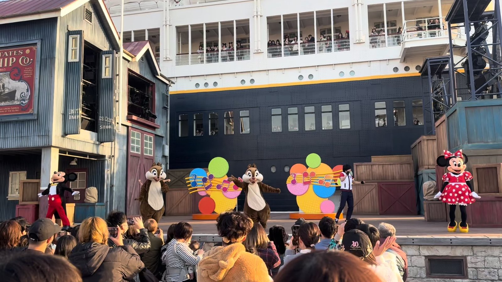 屋外ステージのショーを客席から見ている