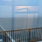 銀鱗荘の部屋の窓から見た小樽の港。防波堤と海、雪の積もった屋根