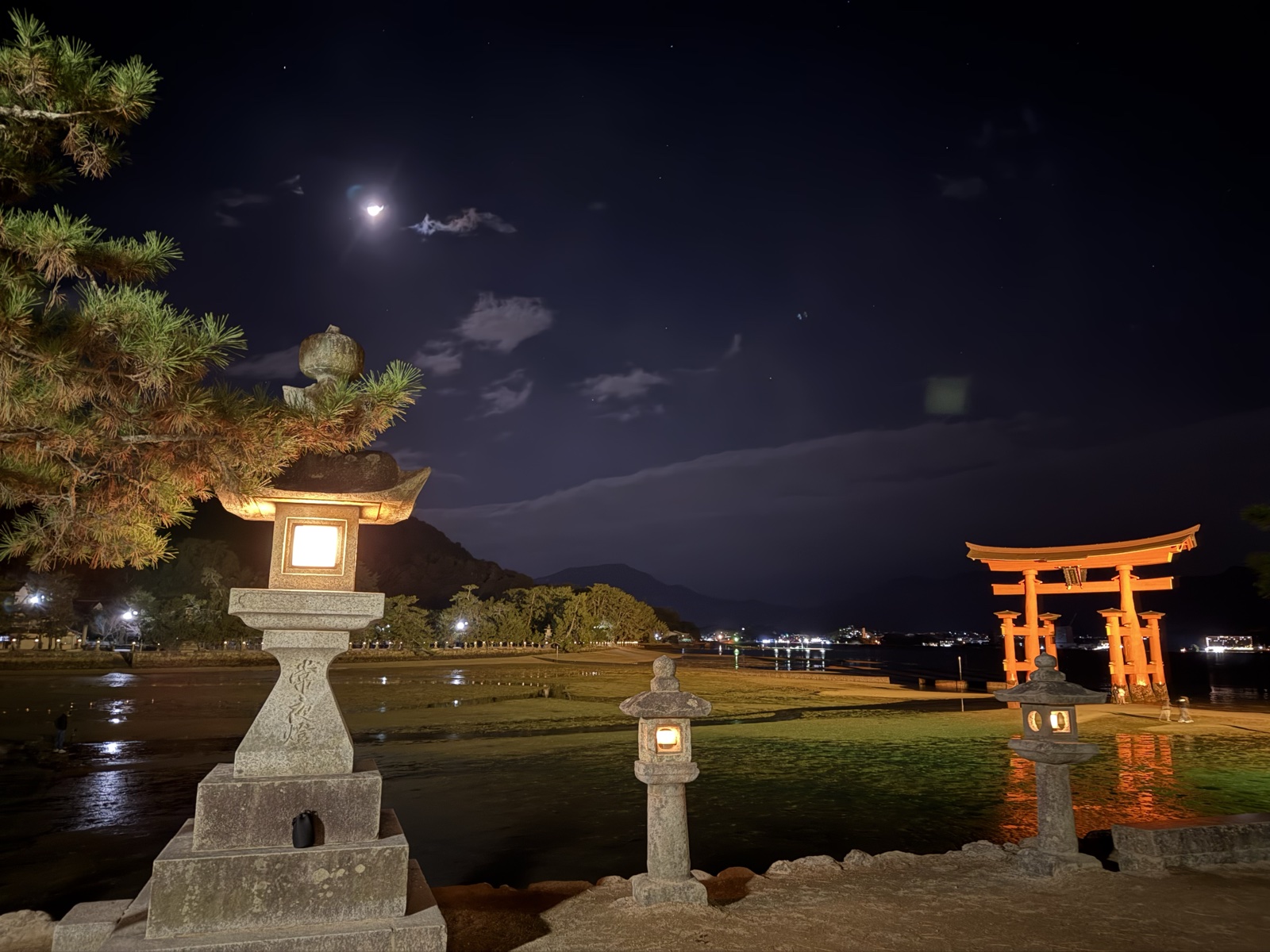 夜の宮島。月と灯籠と海に浮かぶ大鳥居