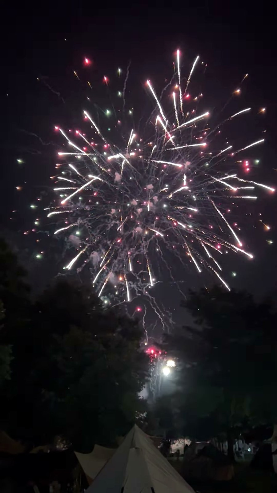 テントの真上に開いた赤と白の花火